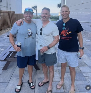 The three Revolution assistant coaches standing together with their arms around each other.