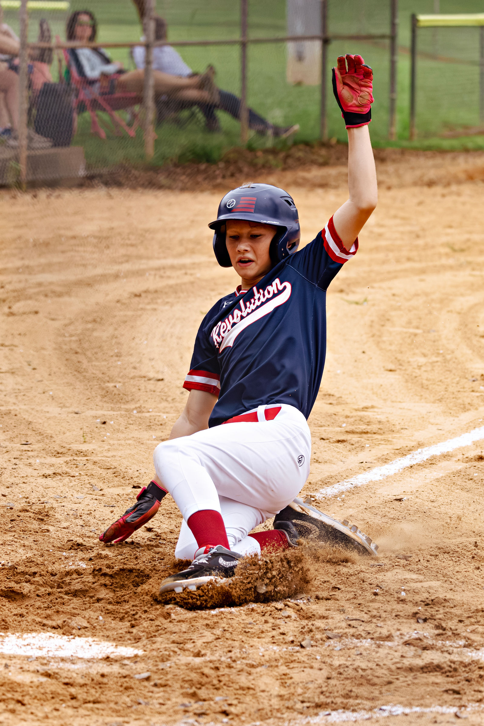 Jaxon JJ Meadows sliding into a base in his navy Revolution uniform.